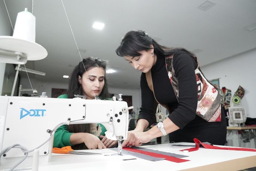 Two makers collaborating at an industrial sewing machine