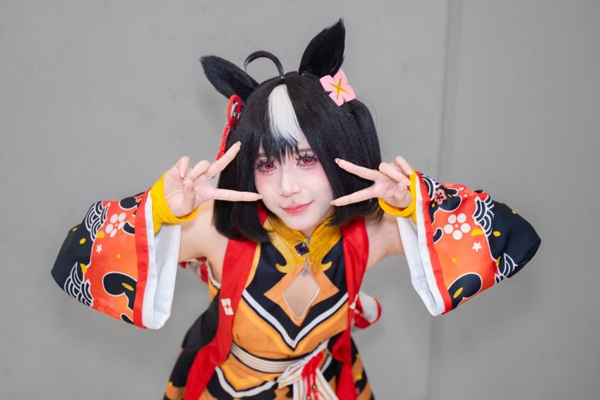 Black-haired character in a bright orange, red and black costume